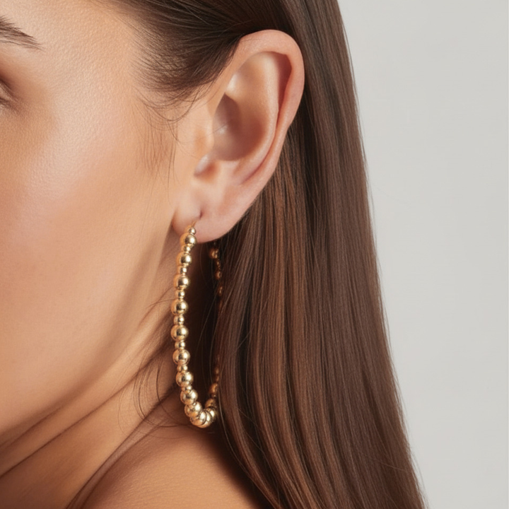 Close-up of a woman wearing 14K Gold Filled Aurelie hoop earrings 