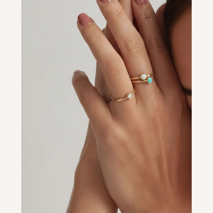 14K Gold Filled Kyza, Opal and Turquoise stacking rings on model's hand close up - demi-fine jewellery by Margot Georgia
