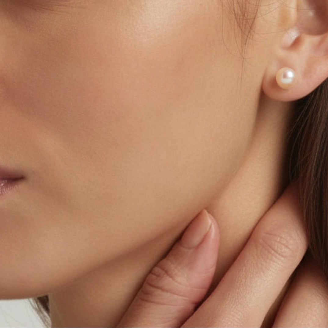 Close-up of an ear showcasing 925 Sterling Silver Lula pearl stud earrings in light pink - demi-fine jewellery by Margot Georgia