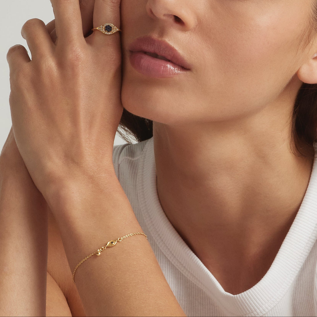 Close-up of a woman's hand wearing the 18K Gold Vermeil Jacalin Evil Eye ring and bracelet