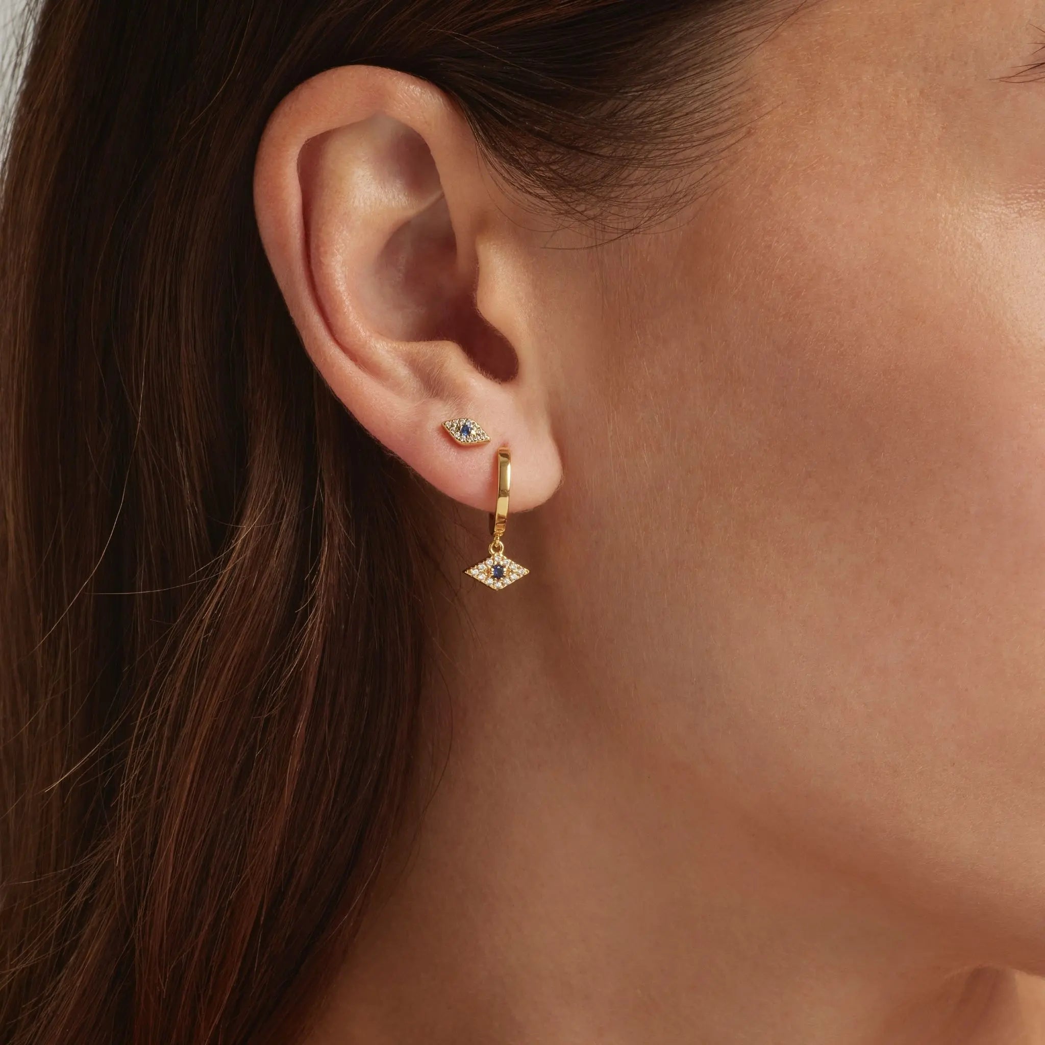 Close up of an ear showcasing the 18K Gold Vermeil Jacalin Evil Eye shaped stud and hoop earrings - demi-fine jewellery by  Margot Georgia