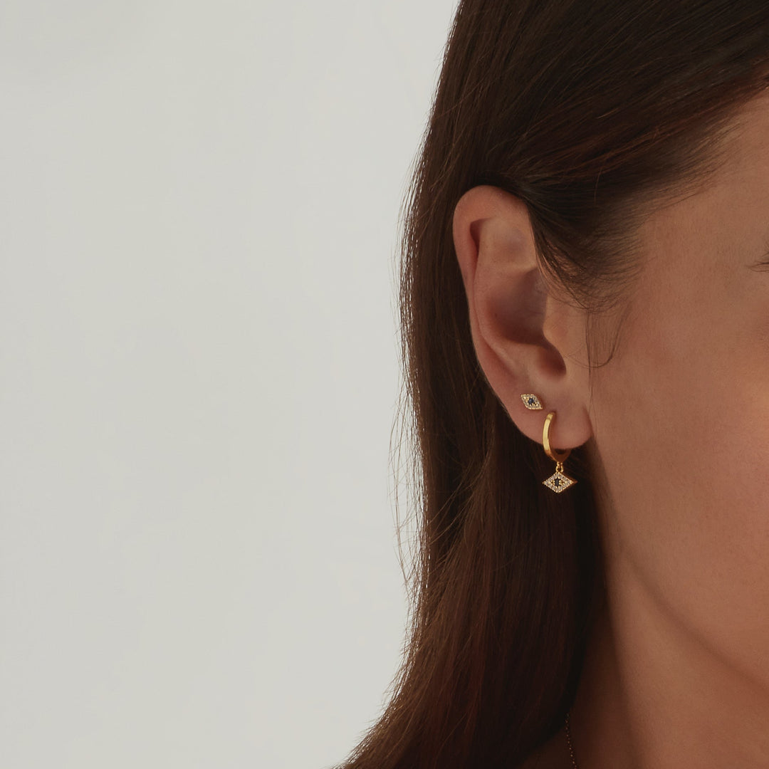 Close-up of a model wearing the 18K Gold Vermeil Evil Eye shaped stud and hoop earrings - demi-fine jewellery by Margot Georgia